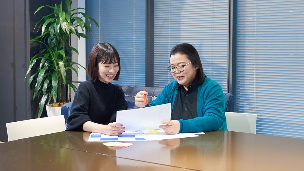 相談している2名のWebデザイナーの写真 