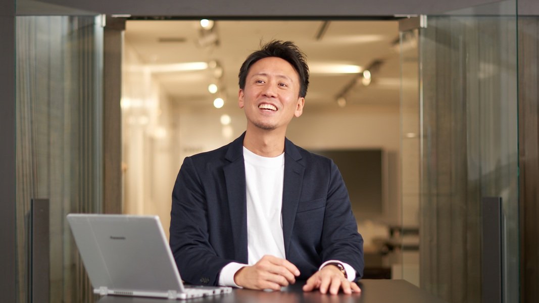 Webプロジェクトマネージャーの大丸寛人（笑顔で話している様子）